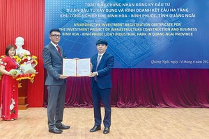 Ông Hà Hoàng Việt Phương, Trưởng Ban Quản lý Khu kinh tế Dung Quất và các Khu công nghiệp Quảng Ngãi (phải) trao Giấy chứng nhận đăng ký đầu tư cho nhà đầu tư Hàn Quốc